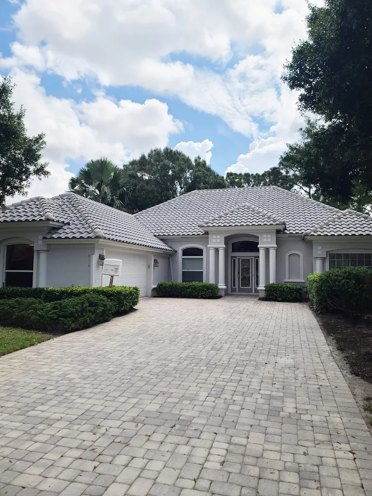 Elegant gray tile roof on Florida luxury home with paver driveway