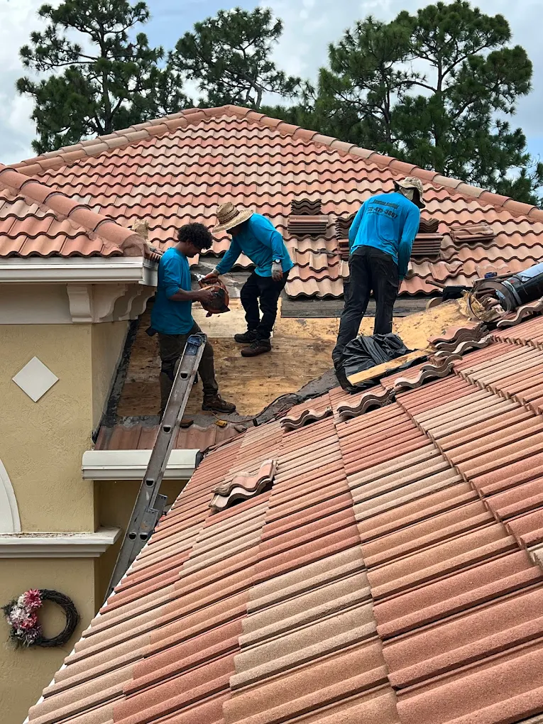 Crew loading new barrel tiles during a tile roof replacement