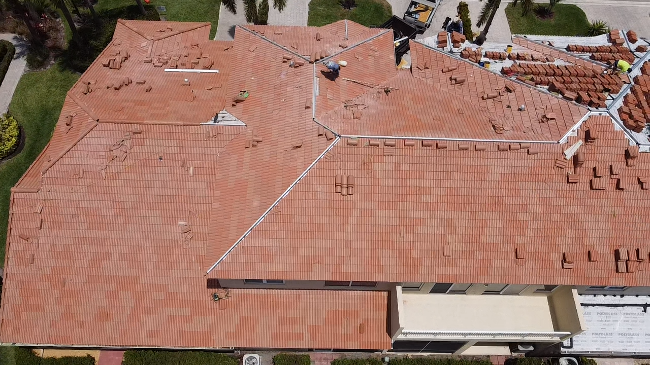Aerial view of concrete tile installation in progress on a large home